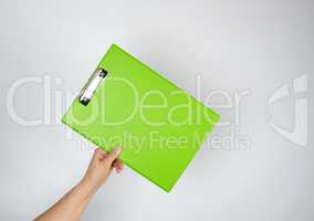 female hand holding a green tablet for clamping papers