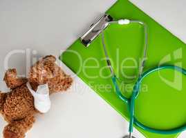 medical stethoscope and green paper holder on a white background