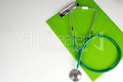 medical stethoscope and green paper holder