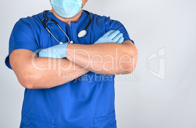 doctor in blue uniform and latex gloves crossed his arms over hi