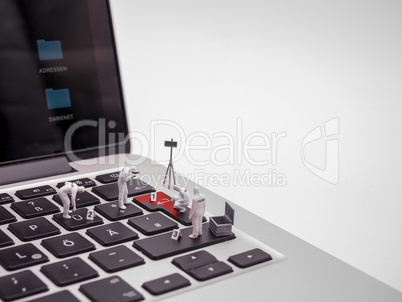 Miniturfiguren Spurensicherung auf Laptop Tastatur
