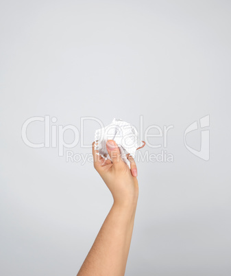 female hand holding white crumpled paper