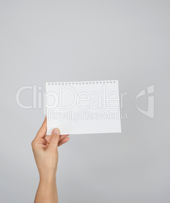 hand holding a blank white sheet in a cell