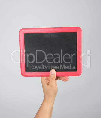hand holding an empty chalk frame on a gray background
