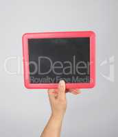 hand holding an empty chalk frame on a gray background