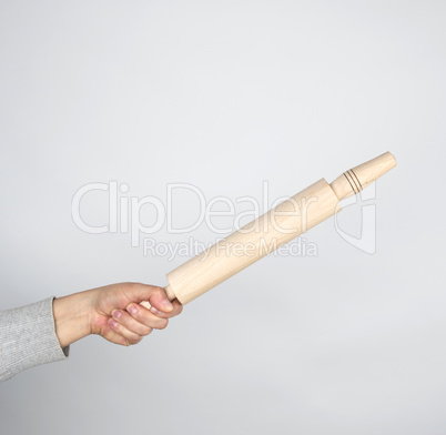 hand holding a wooden rolling pin