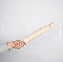 hand holding a wooden rolling pin