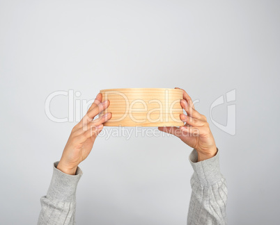 female hands hold round wooden sieve for flour