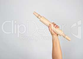 hand holding a wooden rolling pin