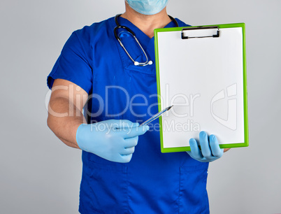 doctor in blue uniform and sterile latex gloves holds a paper cl