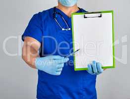 doctor in blue uniform and sterile latex gloves holds a paper cl