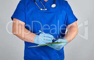 doctor in blue uniform and sterile latex gloves holds clipboard