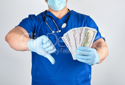 doctor in blue uniform and latex gloves keeps one hand a lot of