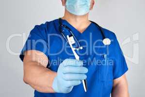 Doctor in sterile latex gloves and blue uniform holding a toothb