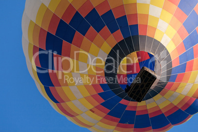 Closeup of a colorful hot-air balloon in flight seen from below