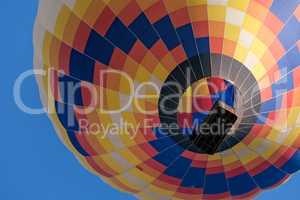 Closeup of a colorful hot-air balloon in flight seen from below