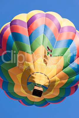 Colored hot-air balloon in flight seen from below