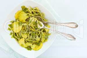 Closeup of linguine pasta with pesto genovese and potatoes over