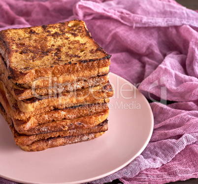 stack of square pieces of fried bread slices on a pink ceramic r