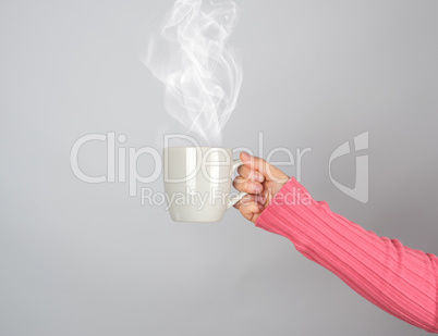 gray ceramic mug in a woman's hand