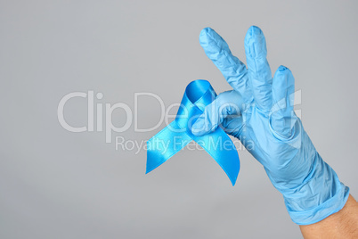 hand in blue latex glove holding a blue ribbon