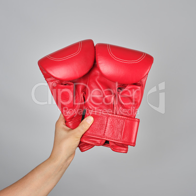 pair of red leather boxing gloves in female hand