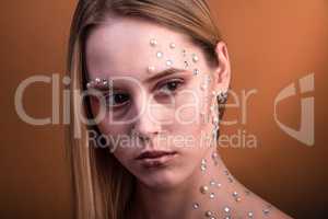 Girl with white and pearl rhinestones on her face.