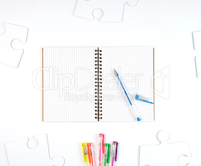 open notebook in a cell and a blue pen on a white background