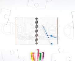 open notebook in a cell and a blue pen on a white background