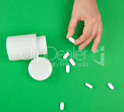 white plastic can and scattered oval pill