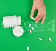 white plastic can and scattered oval pill