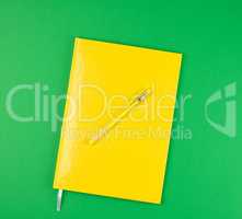closed notebook and yellow pen