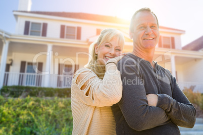 Attractive Middle-aged Couple In Front Of Their House