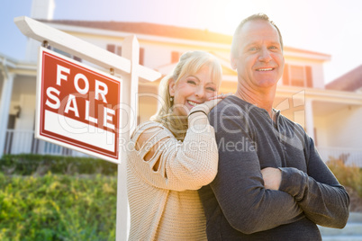 Attractive Middle-aged Couple In Front House and For Sale Sign
