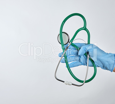 blue sterile gloved hand holding a green medical stethoscope