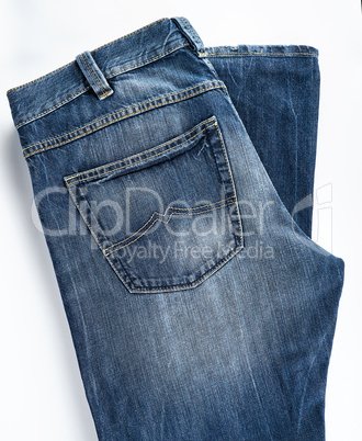 folded blue men's jeans on a white background