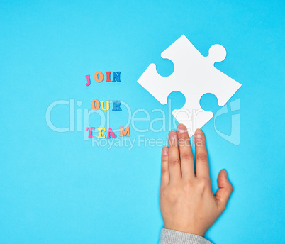 hand hold  large white puzzles and the inscription join our team