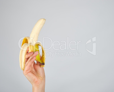 peeled fresh banana in female hand