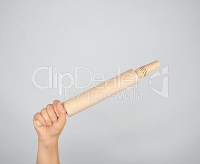 hand holding a wooden rolling pin