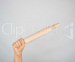 hand holding a wooden rolling pin