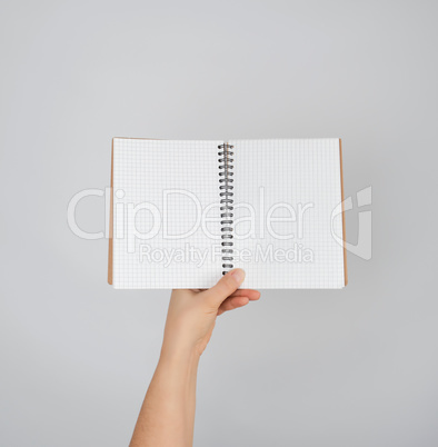 female hand holds open  notepad