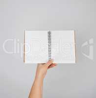 female hand holds open  notepad
