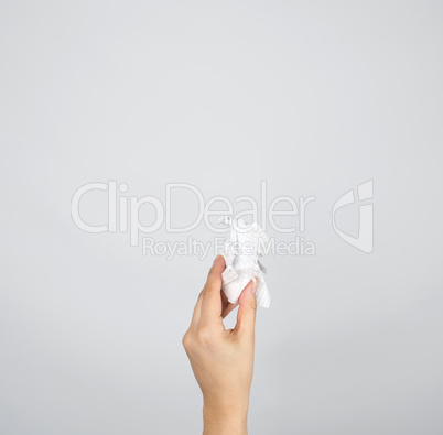 female hand holding white crumpled paper