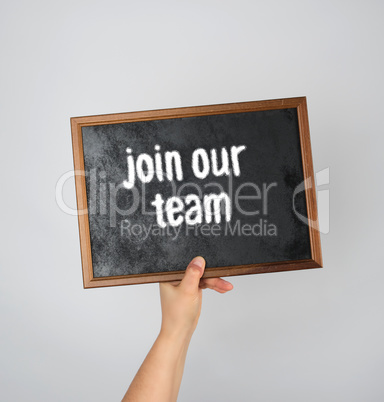 hand holding an empty wooden chalk frame on a gray background