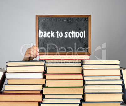 stack of various hardcover books and wooden brown chalk frame