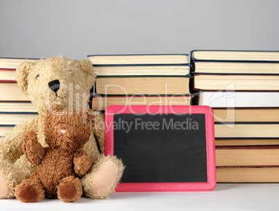 brown teddy bear and empty black board in red frame on the backg