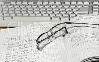 Notebook and glasses and keyboard