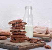stack of round chocolate chip cookies on a brown wooden board