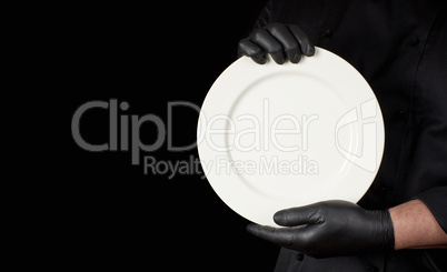 Chef in black uniform  holding a round white empty plate