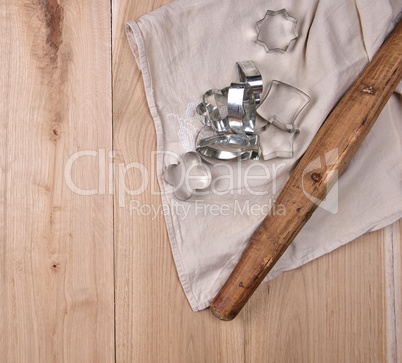 wooden rolling pin and iron bakeware on a brown wooden table
